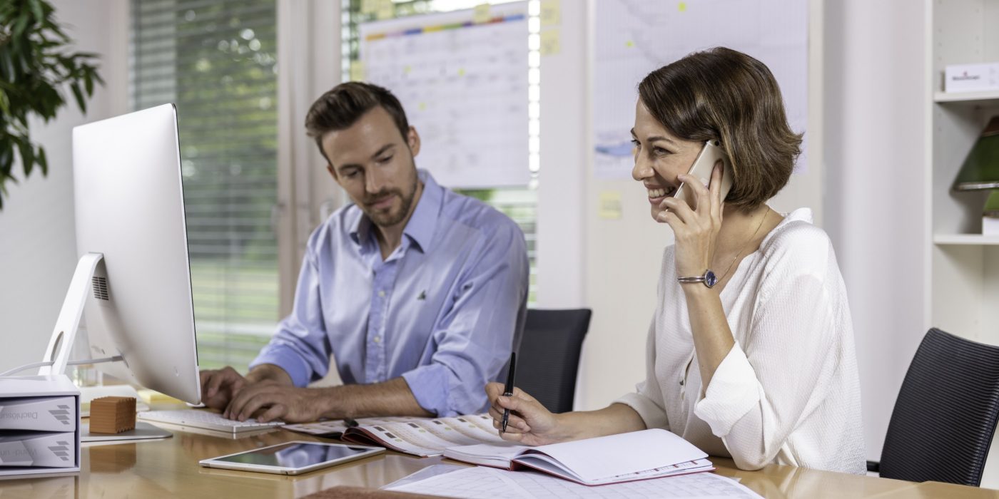 Male and female project manager collaborating in front of computer screen at office, Fast Forward Procurement