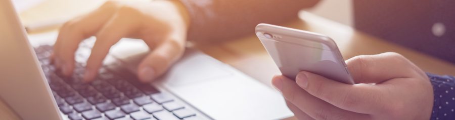Young man working with iPhone and Laptop